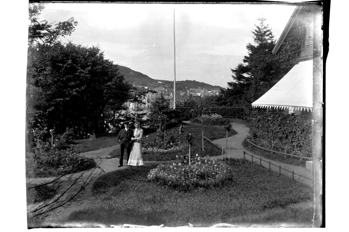 Rolf Sr. Sundt, Trilling(?) med dame i hagen til konsul Sundt på Farøy. I bakgrunnen Farsund. Antagelig fotografert 1903-04.