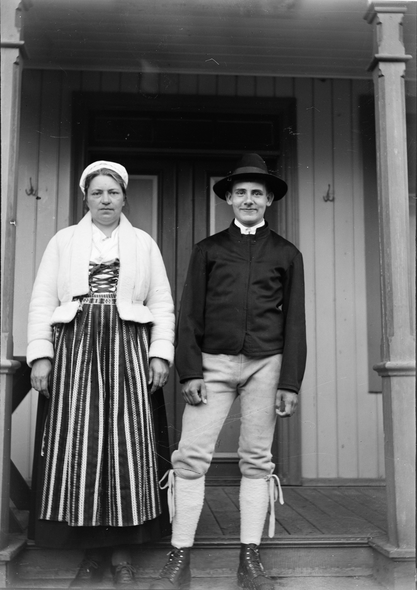 Okänd,, Christiane Liljefors med sonen Roland, klädda i Leksandsdräkter, står på trappan framför bostadshus, sannolikt på Svensgården, Dalarna, Sverige