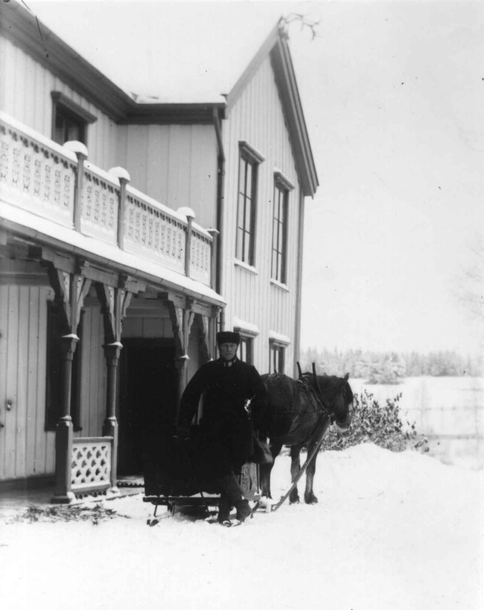 Fredrik Emil Faye, Dal gård, Ullensaker. Mann med hest og kjøretøy foran hovedbygningen vinterstid. Fra serie fotografert av kammerherre Fredrik Emil Faye (1844-1903), gårdens eier.