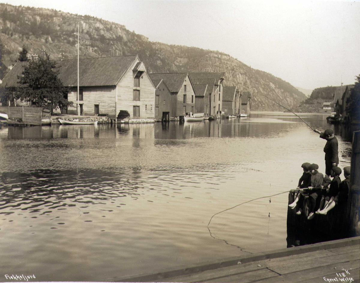 Anders Beer Wilse, Sjøboder, Flekkefjord, Vest-Agder. Gutter fisker i forgrunnen. Fotografert 1912.