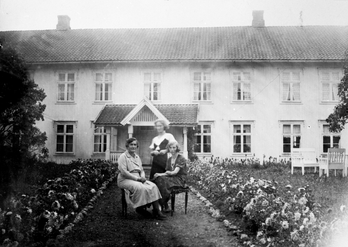 Anno Domkirkeodden, Eksteriør, hovedbygningen på Fossum, Nes, Hedmark. 3 damer ved blomster bed. Anna Storlien f.1875 med sine døtre Magdalena Sterud (1902-1994), Asbjørg Haram f.1909.