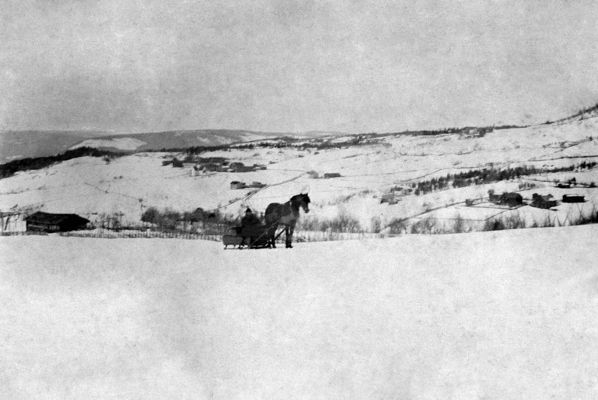 Anno Domkirkeodden, Oversikt Brøttum sentrum sett fra Alm øvre. Hest med slede i forgrunnen. Hovedvegen gikk gjennom låven på Mæhlum. Vinter.