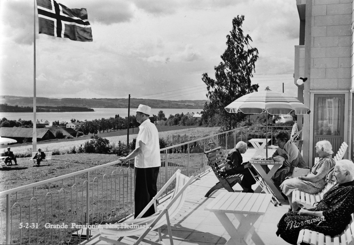Anno Domkirkeodden, Flagg på Grande Pensjonat, senere Grande Rekreasjonsheim, Nes, Hedmark. Beboere på terrassen.