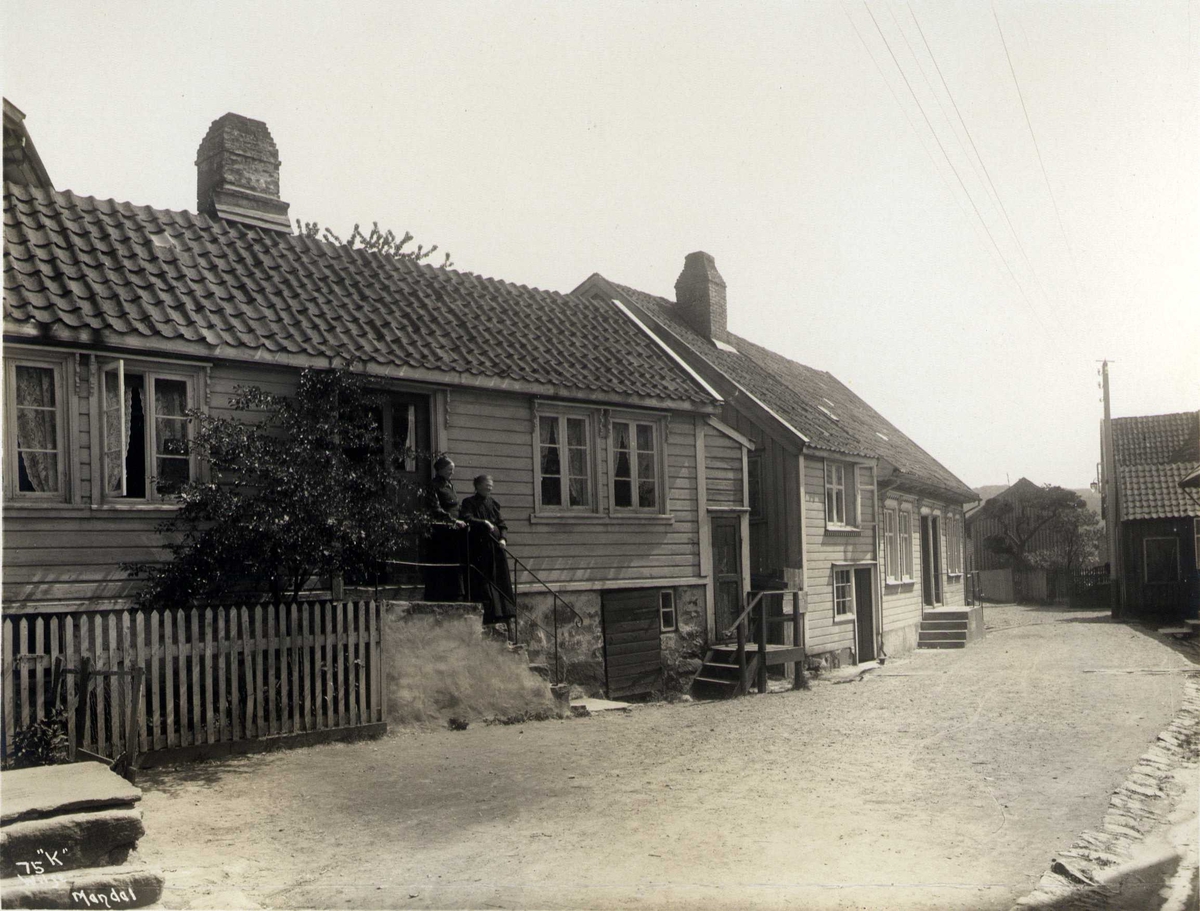 Anders Beer Wilse, Gateparti, Mandal, Vest-Agder. Fotografert 1912. To damer på trapp i forgrunn.