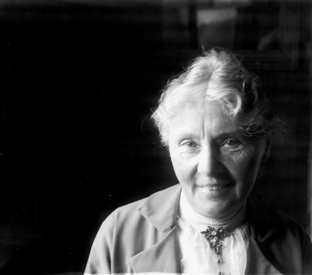 Juliane Fredrikke Langberg, Portrett av eldre kvinne, nærbilde. Hun er kledd i jakke med bluse og halssmykke. Muligens på kappelangården Bergenhus i Rakkestad eller prestegården i Hurum, hvor fotografens søster Louise var gift med presten Olaf A.Holm. Fra malerinne Juliane Fredrikke Langbergs (1856-1930) samling, tatt ca.1895…