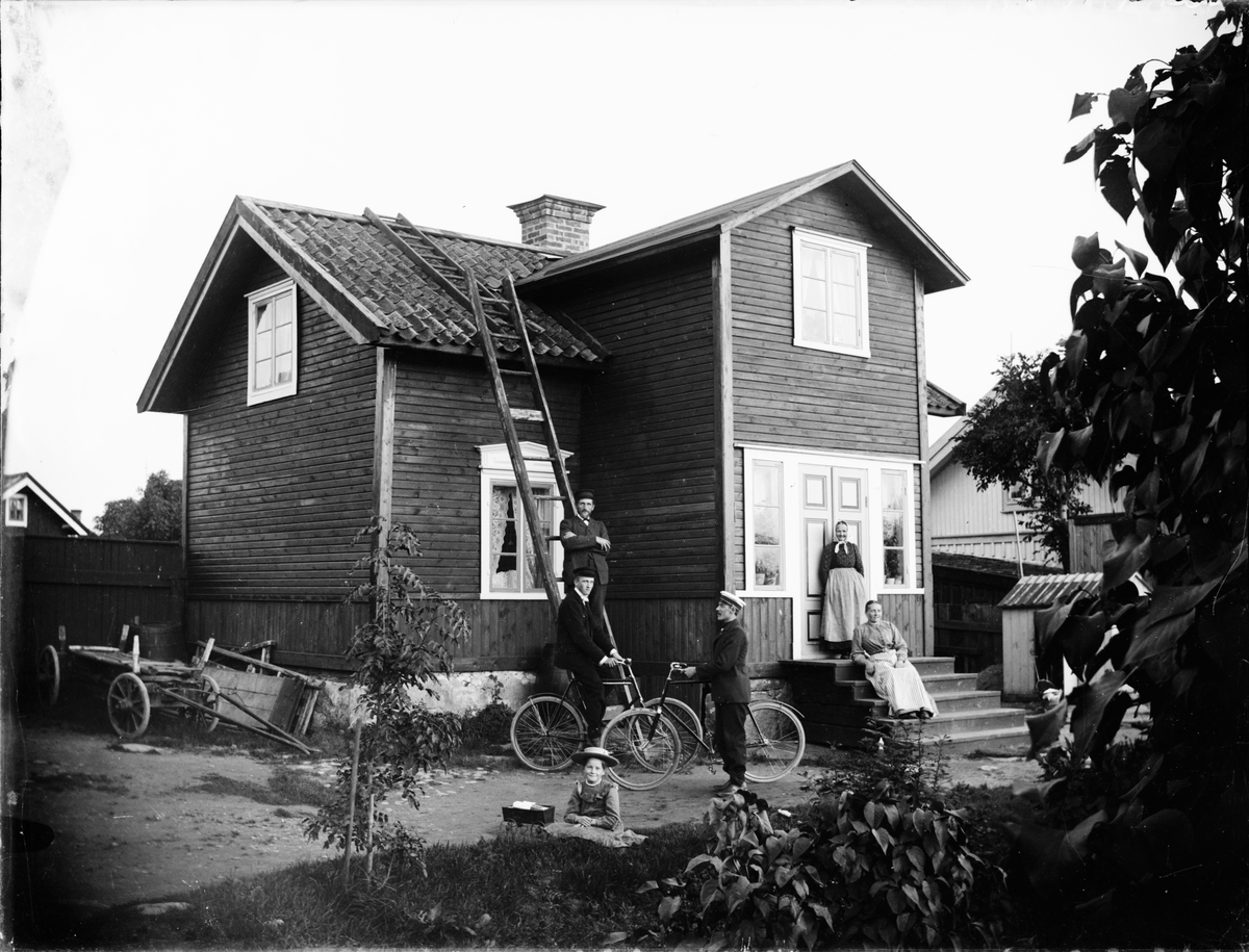 Skötsner-Edhlund, Män, kvinnor och barn framför bostadshus, Östhammar, Uppland