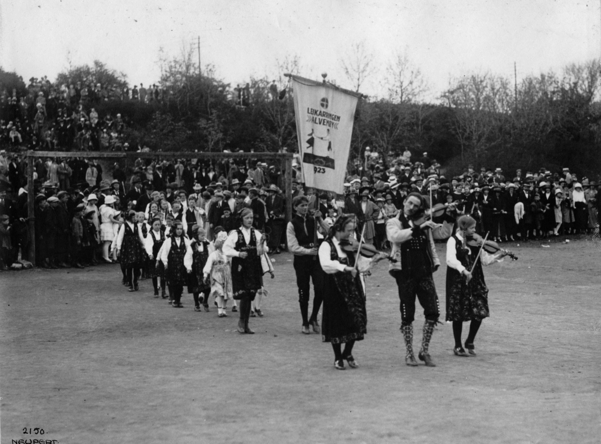 Hermann Christian Neupert, Folkedansere på vårfest på Hovedøya, Oslo 1924. Felespillere i spissen for prosesjon av barn i bunader. Publikum.