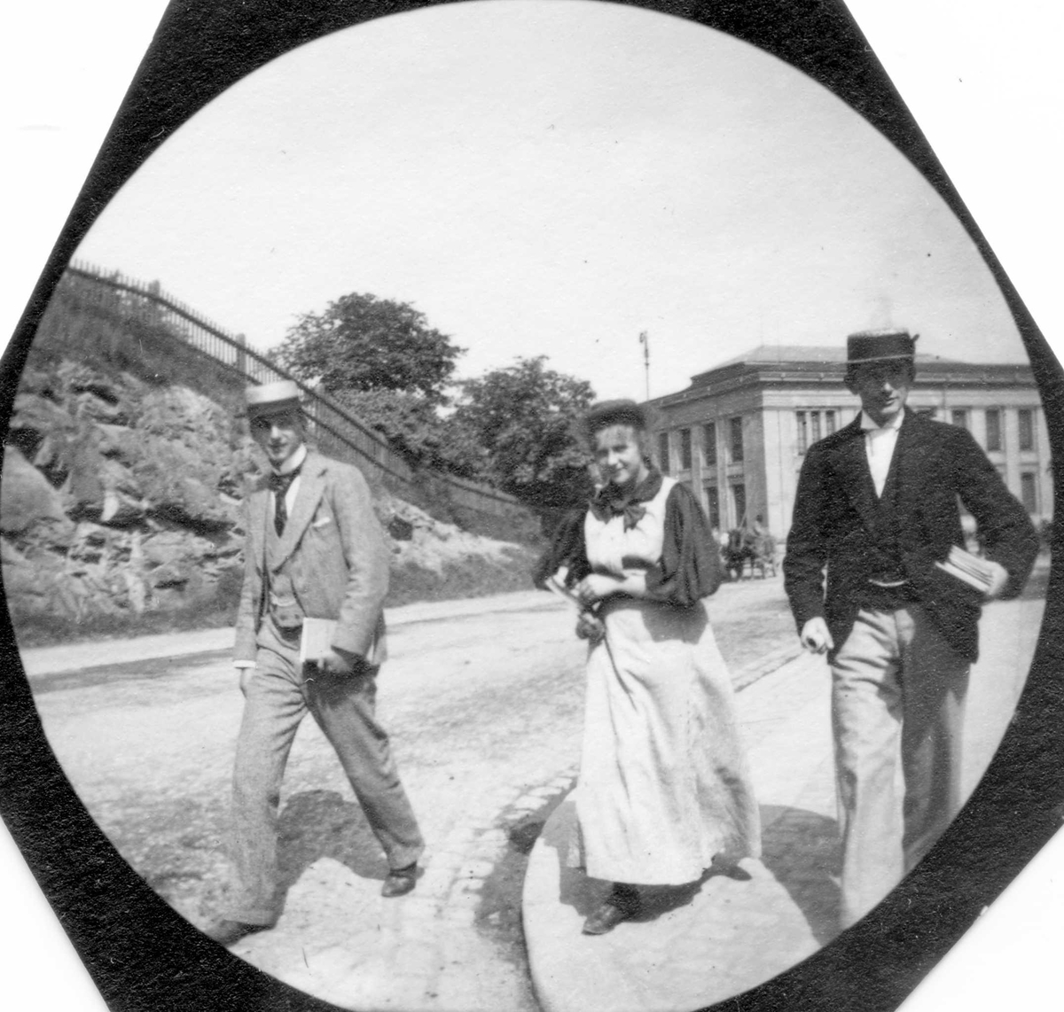 Fredrik Carl Mülertz Størmer, To menn og en kvinne spaserer langs Drammensveien, Oslo. Slottsparken og Universitetet bak.