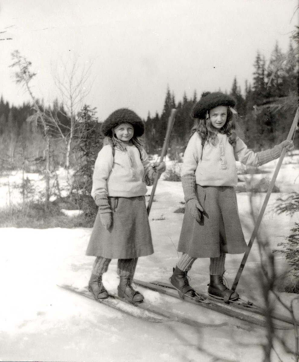Axel Quinsgaard Wiborg, Dobbeltportrett, Gudrun og Karen Q. Wiborg, Holoa seter, Hadeland, Jevnaker, Oppland, 1906. Pikene er fotografens døtre og går på ski i skidrakter. Antatt del av stereofotografi (se relaterte objekter). Fra serie tatt av iseksportør Axel Quinsgaard Wiborg (d. 1944).
