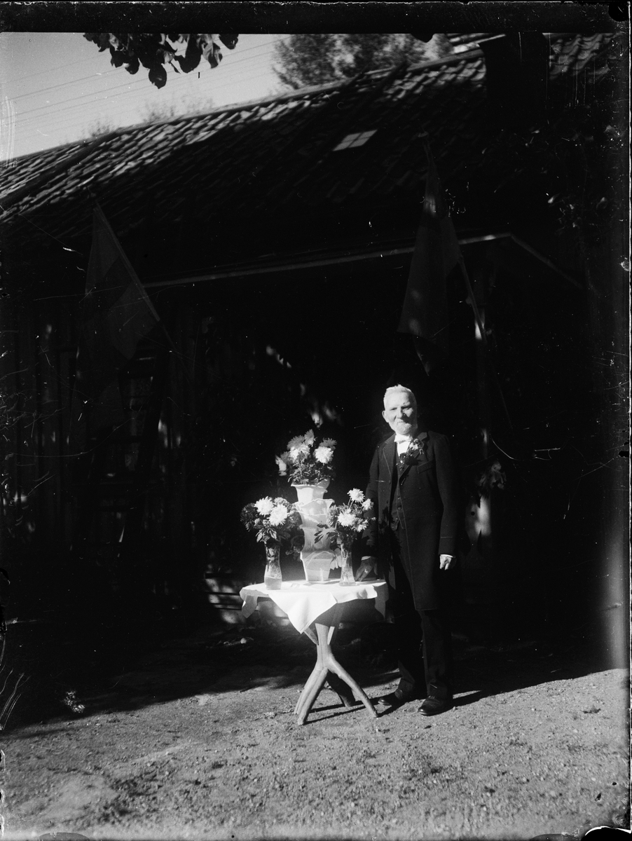 Skötsner-Edhlund, Man standing by table with flowers, Uppland