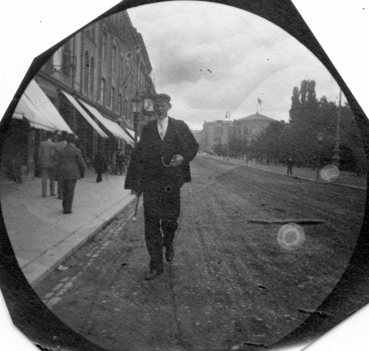 Fredrik Carl Mülertz Størmer, Stud. med. Berg spaserer på Karl Johans gate, Oslo, med Stortinget i ryggen. Student fra Kathedralskolen 1892.