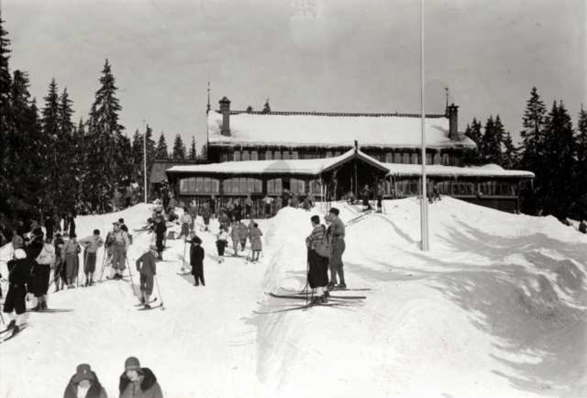 Hermann Christian Neupert, Frognerseteren Restaurant, Nordmarka, Oslo. Vintermotiv. Skiløpere foran restauranten.