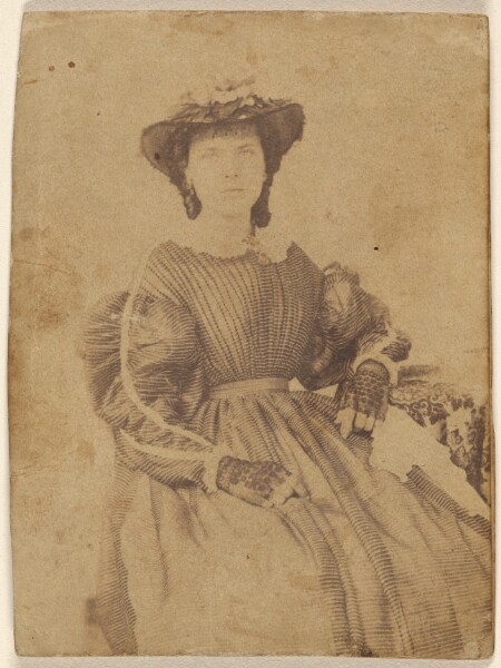 Unknown, [Unidentified woman wearing a hat and open-fingered gloves, seated]