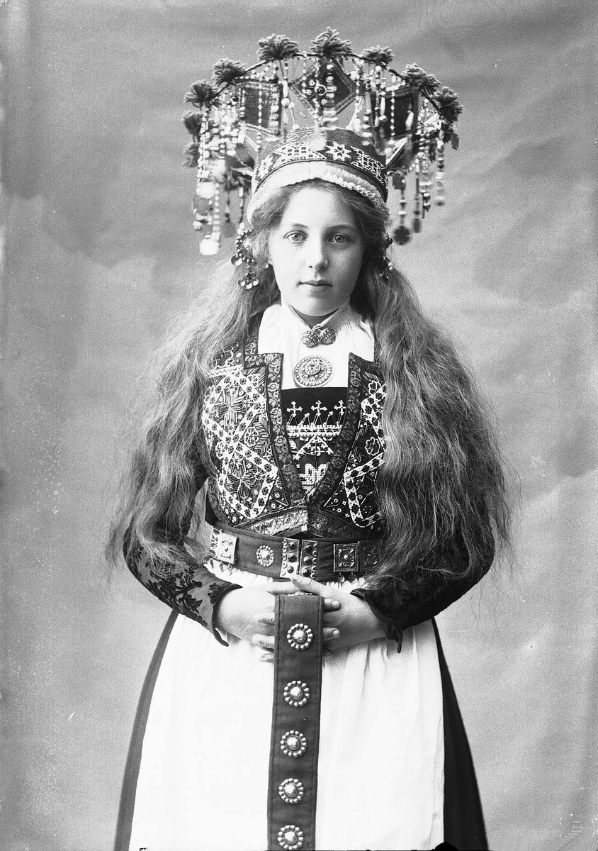 Solveig Lund, Studiofotografi av kvinne med brudedrakt og brudekrone. Stående med utslått hår. 3/4 dels utsnitt. Frontalt vendt. Ser på betrakteren.