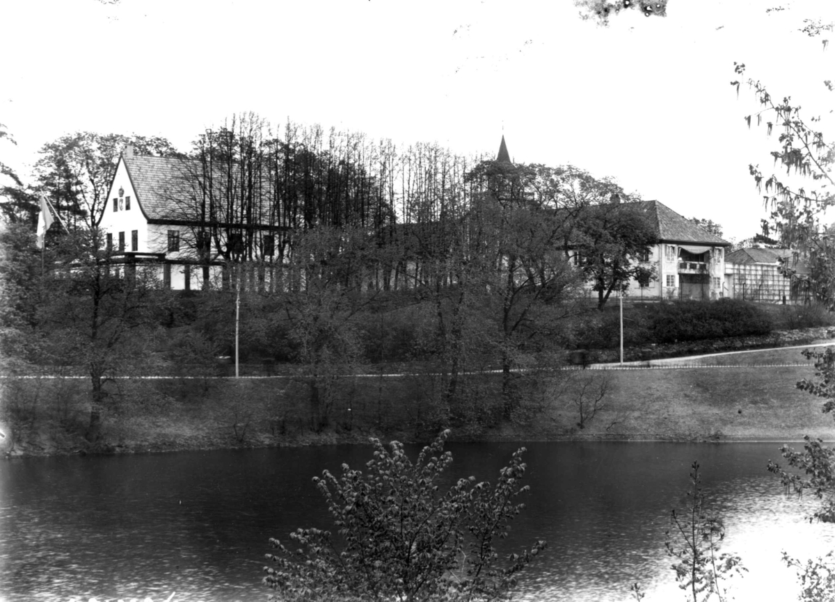 Hermann Christian Neupert, Jubileumsutstillingen på Frogner, Oslo, 1914. Parkområde. Frogner Hovedgård med Bergen bys paviljong til venstre. Dam i forgrunnen.