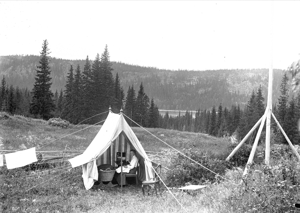 Axel Quinsgaard Wiborg, Holoa seter, Hadeland, Jevnaker, Oppland, 1903. Kvinne sitter i telt med kurv.