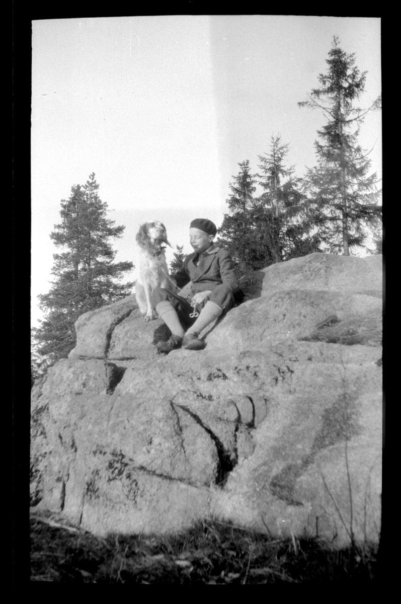 Rolf Sr. Sundt, Einar Aubert Hansen sitter på en fjellknaus med en hund.