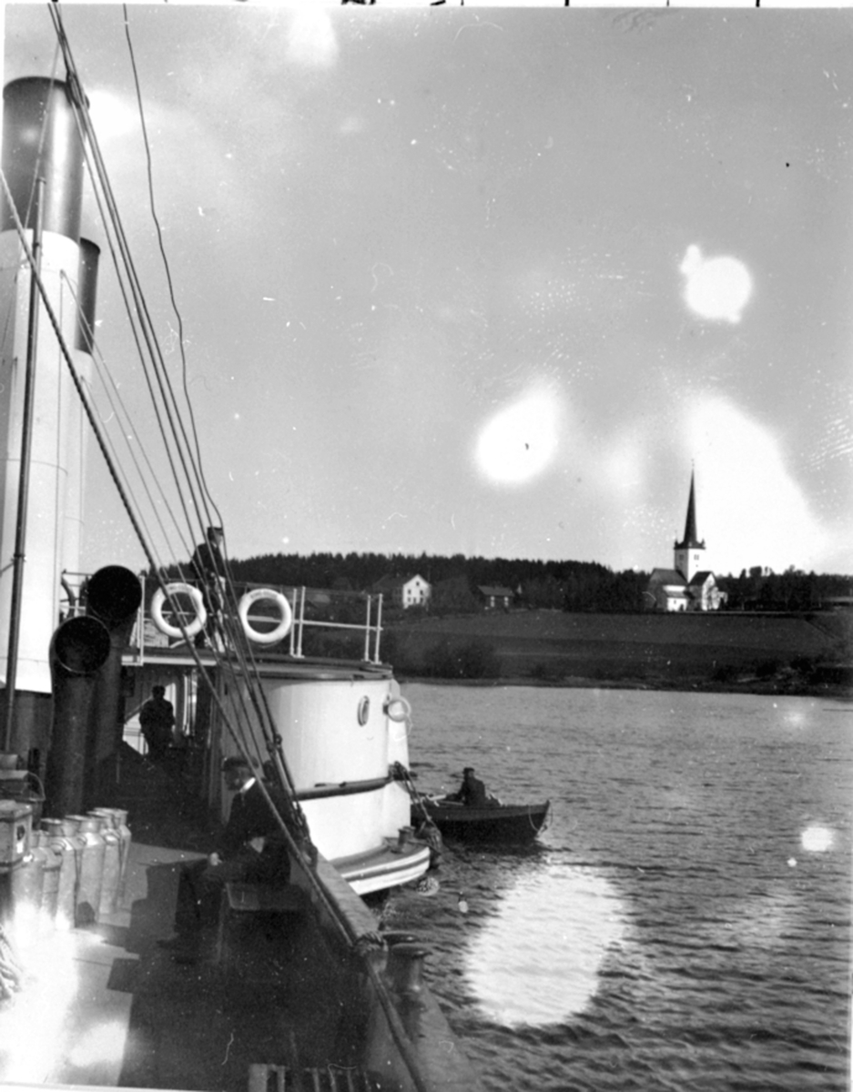 Anno Domkirkeodden, Mjøsbåten D.S. Kong Oscar på vei ut fra Ringstrand brygge ved Ringsaker kirke. Mjølkekjeler ombord. Robåt ved siden.