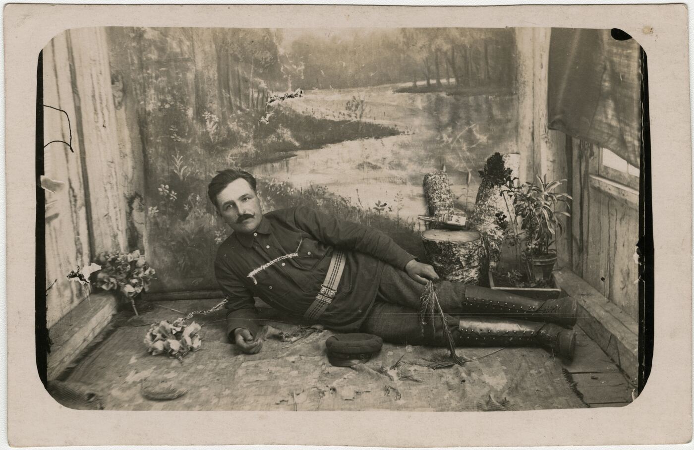 Nežinomas fotografas, Ant kilimo gulinčio vyro portretas fotostudijoje
