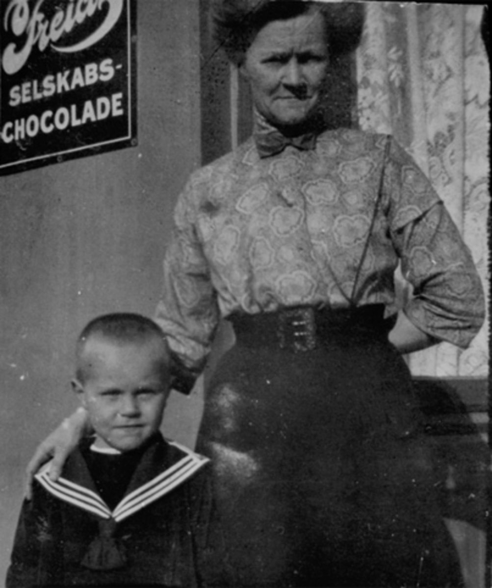 Anno Domkirkeodden, INTERIØR JOHANNESSENS BAKERI & KONDITORI, DAME OG GUTT MED MATROSDRESS, REKLAMESKILT FOR FREIA SELSKAPS-CHOCOLADE I BAKGRUNNEN