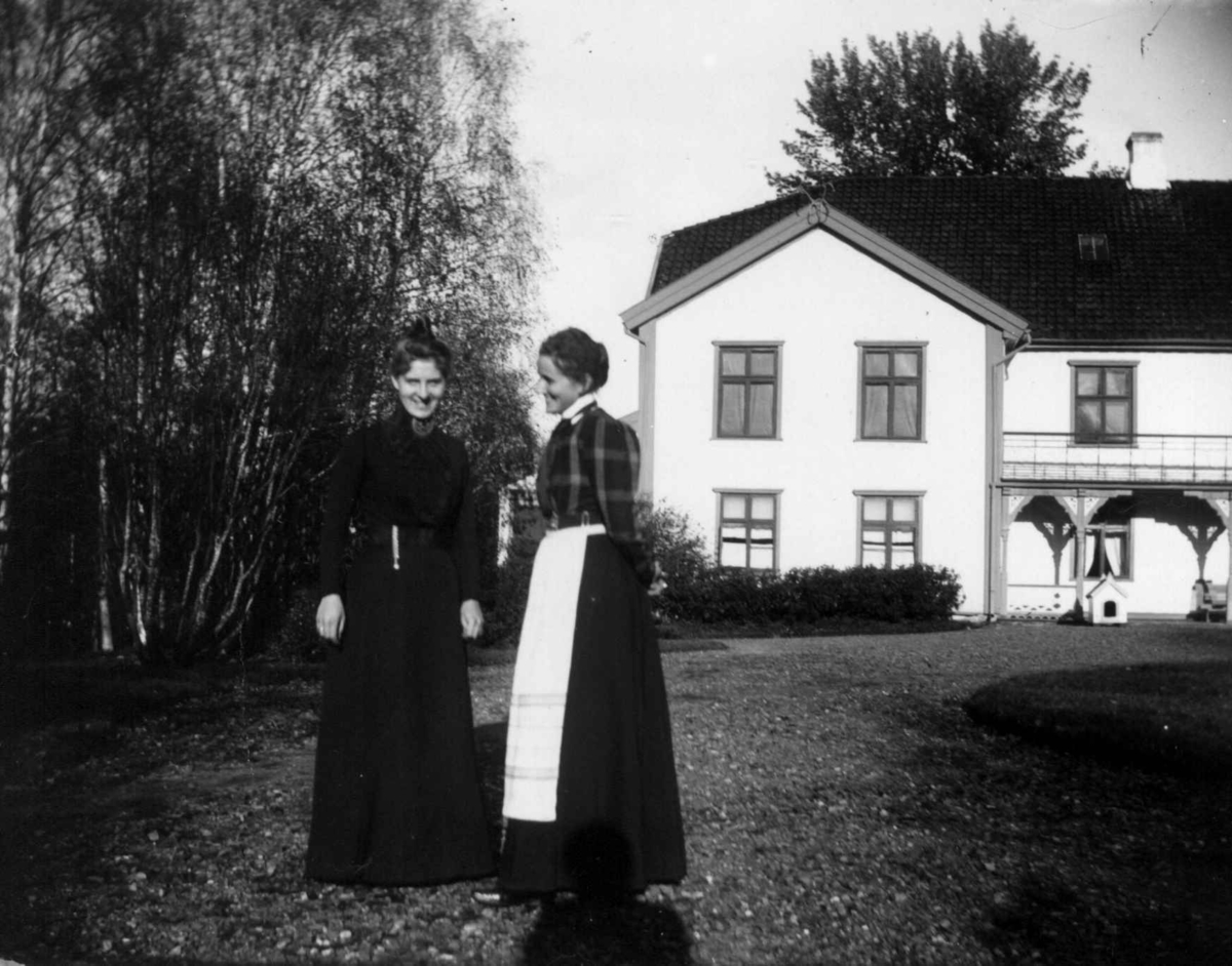 Fredrik Emil Faye, Dobbeltportrett, frk.Ester Lind (senere fru jernbanedirektør Andreas Jynge) og Selma Faye, 1897. I hagen foran hovedbygningen. Lind var guvernante hos Fayes på Dal, før hun giftet seg. Fra portrettserie av personer som bodde på eller besøkte Dal gård, Ullensaker, fotografert av gårdens eier, kammer…