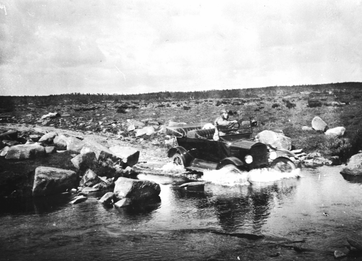 Anno Domkirkeodden, Karl Løken kjører bil, en Ford T 1919-22 modell, D-111 over en bekk i Ringsakerfjellet.
