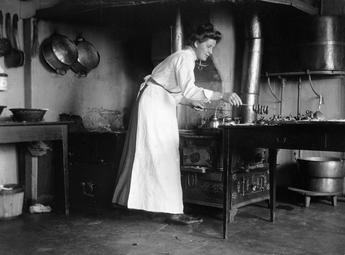 Anno Domkirkeodden, Rømma østre, Løten. Interiør, bryggerhuset, baking, Emma Søberg koker smultringer, vedkomfyr, kjøkkenredskap.