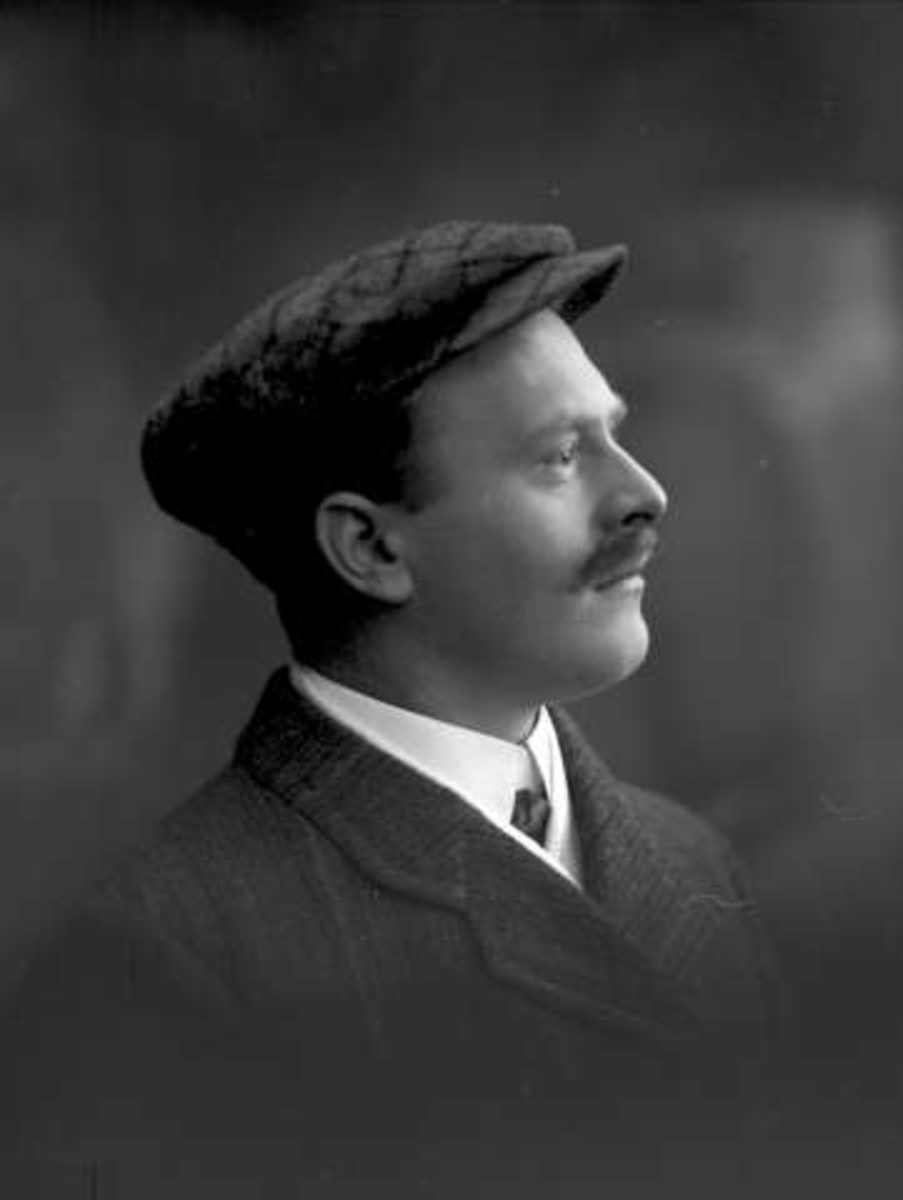 Gustav Borgen, Portrett, mann med dress og lue. Herr kontorsjef Mørck.