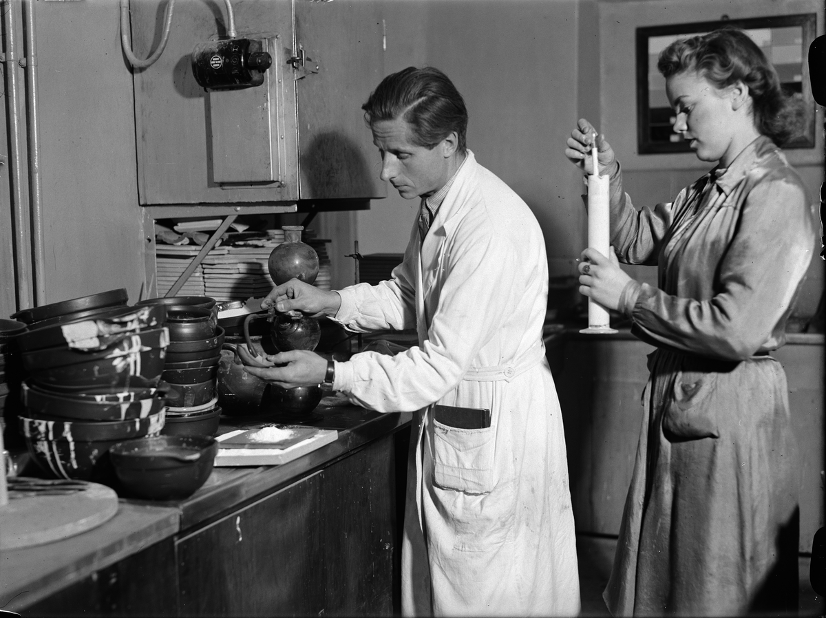 Paul Sandberg, Ingenjören Erik Augustin "biträdd av assistenten fröken Svensson" i laboratorium på Upsala-Ekeby AB, Flogsta