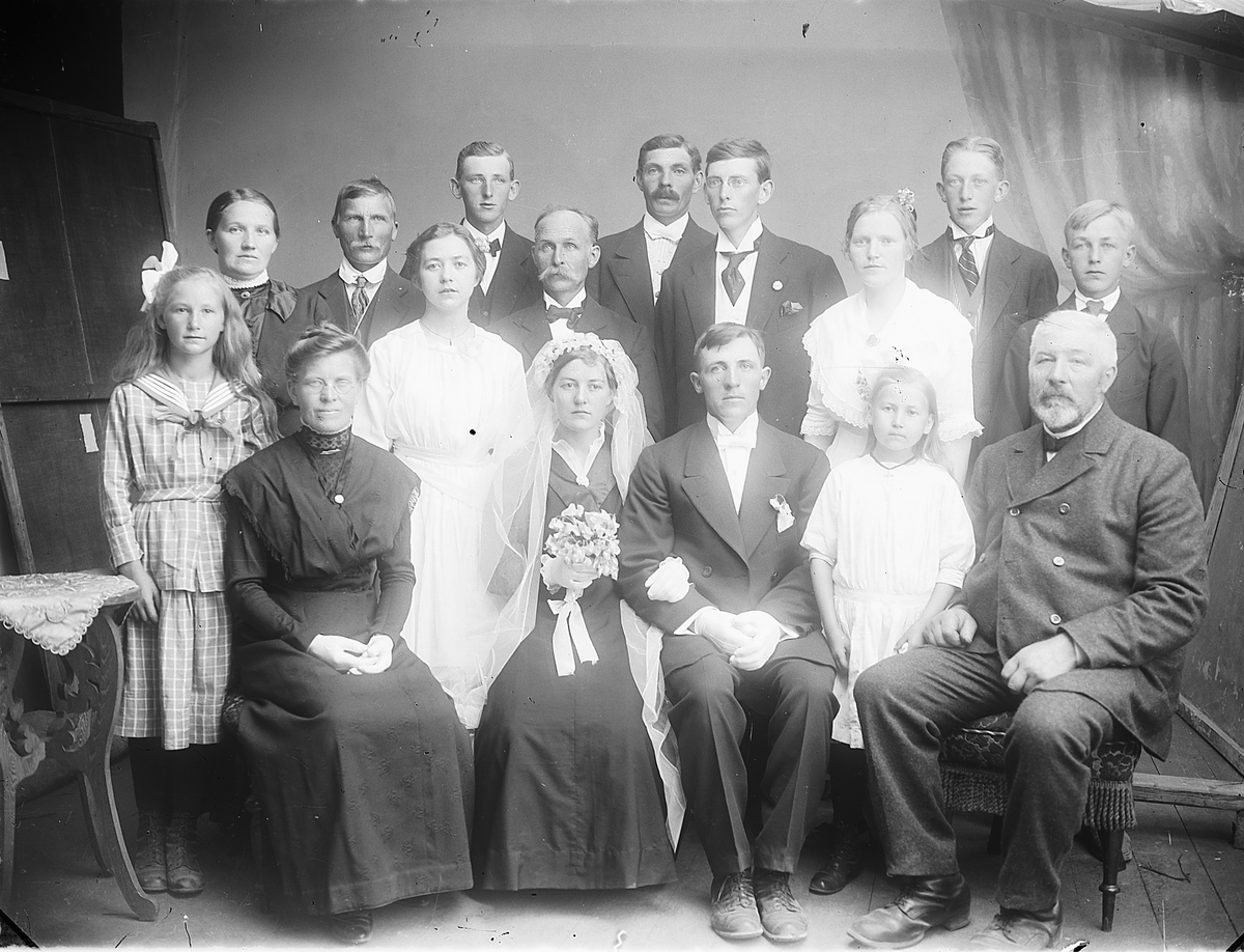 Martin Finborud, Brudepar. Ole Johannesen Bøvolden (1893-1974) og Emilie Evensdatter Støen (1896-1972) med familie. Sittende fra venstre er Klara Støen (1875-1967), brudeparet, Margrethe Støen (1904-1992), Johannes Knutsen Bøvolden f.1857. Stående fra venstre (etter ansiktsplassering) er Kristiane Støen, Marie Joha…