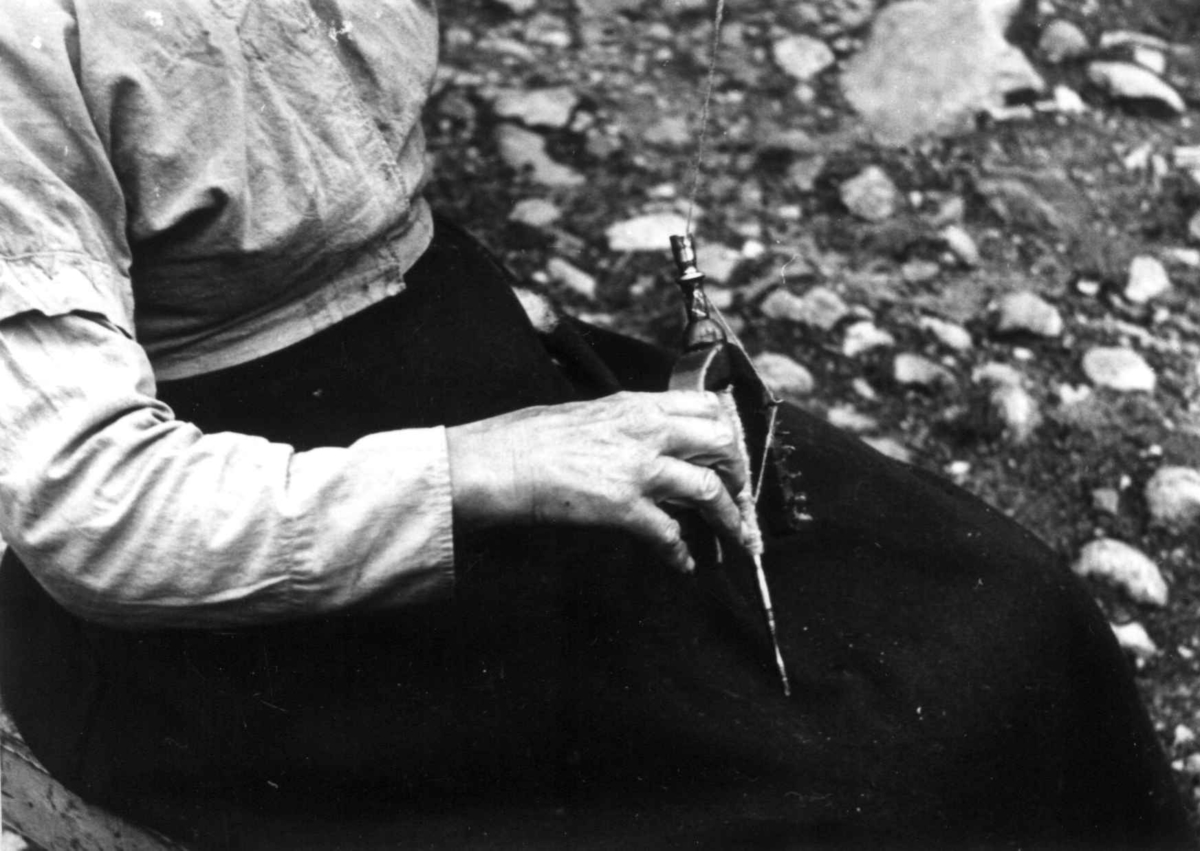 Anna Grostøl, Vinje, Rauland, Telemark 1939. Gro Vå spinner på håndtein.