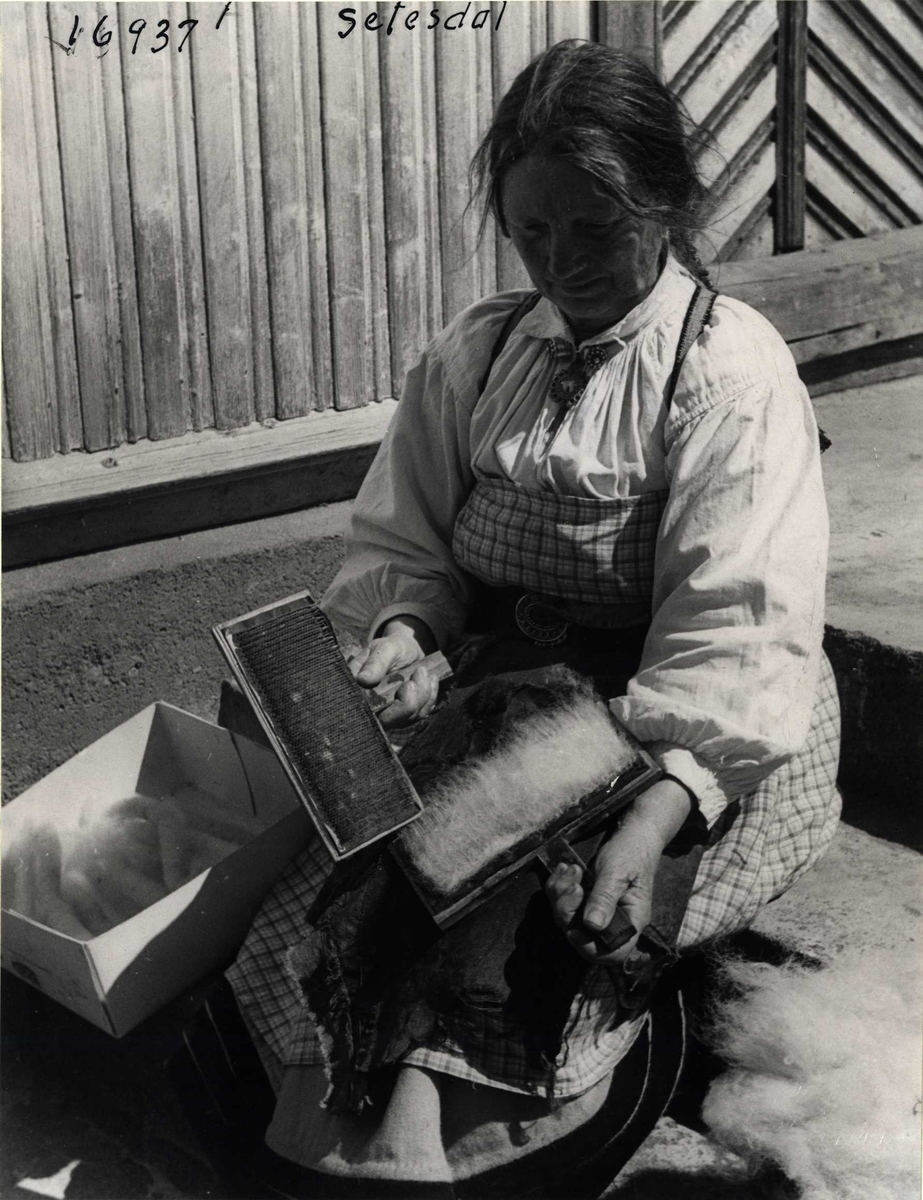 Anders Beer Wilse, En kvinne karder ull. Setesdal, Aust-Agder, 1943.