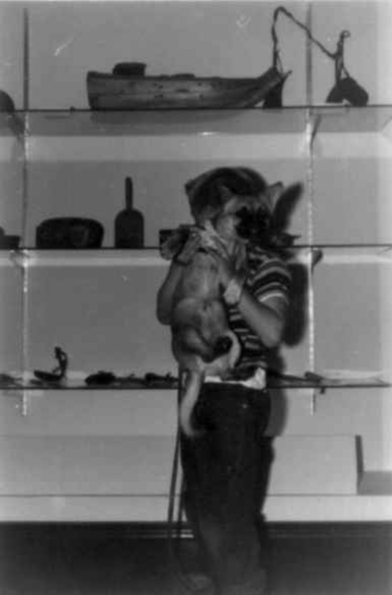 Virginia Raymond Davidson, Gutt med hund foran utstillingsmonter med forskjellige gjenstander fra samisk utstilling i California 1963.
