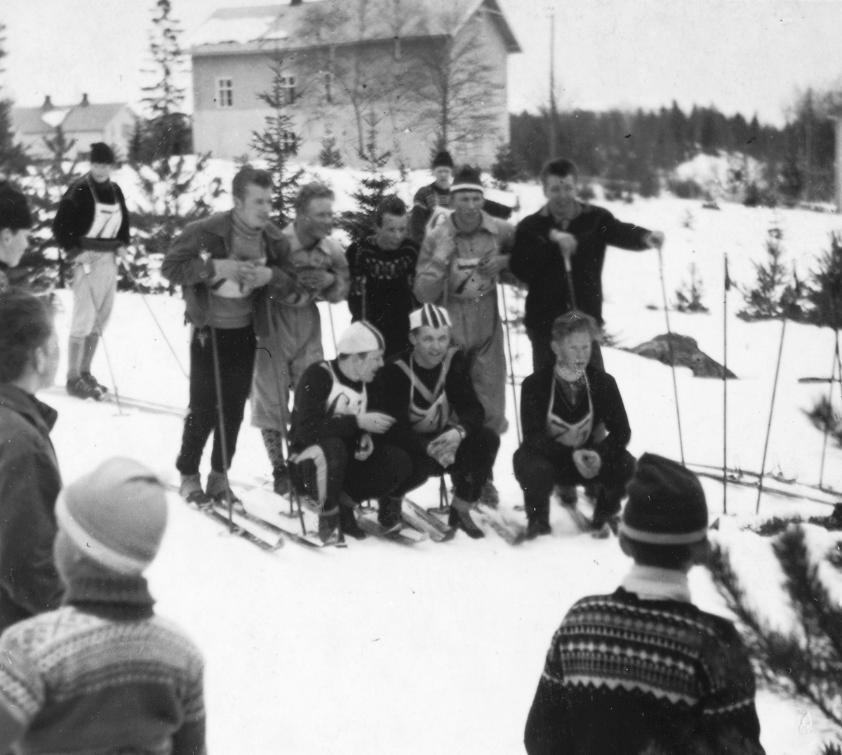 Anno Domkirkeodden, Skirenn, arrangert av AUF, og het det Røde skirenn. Hekne skole, Åsbygda. Tatt fra området ved lærerboligen. Kringlebo til venstre. I første rekke fra venstre Tore Andersen, Arvid Andersen og Jan Bysveen. 2 rekke fra venstre Oddbjørn Grinden, Asbjørn Harildstad, Tormod Holen, Arild Huse og Karstein…