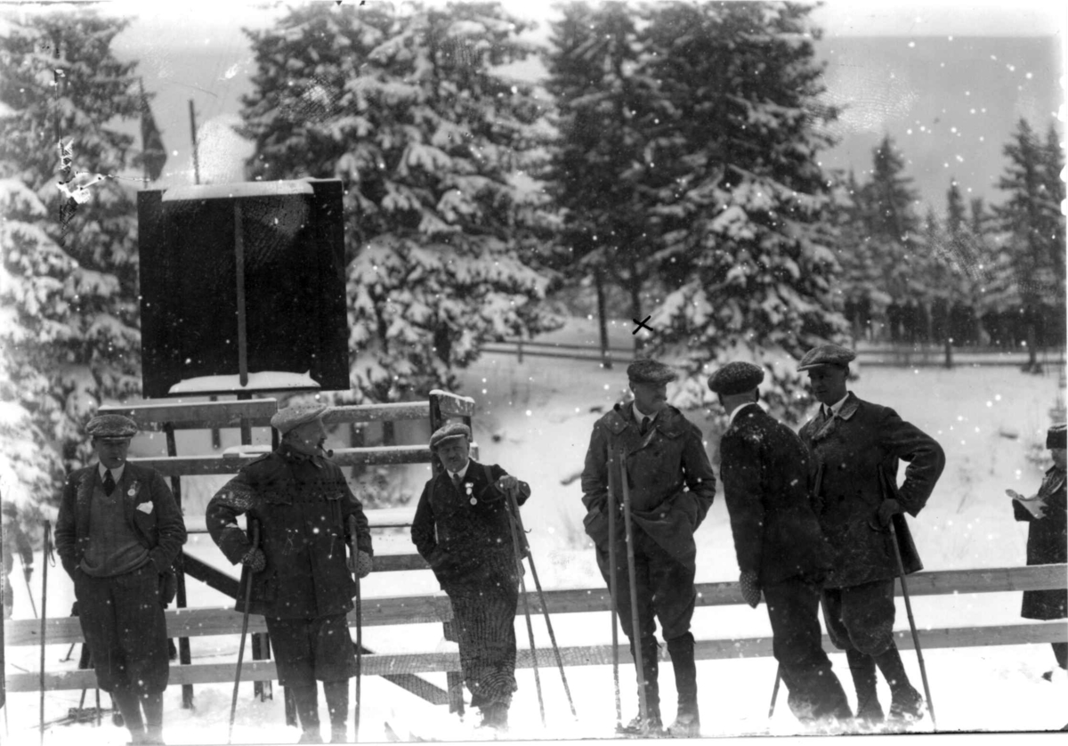Hermann Christian Neupert, Kong Haakon VII på Holmenkollrenn. På ski. Publikum. Skog.
