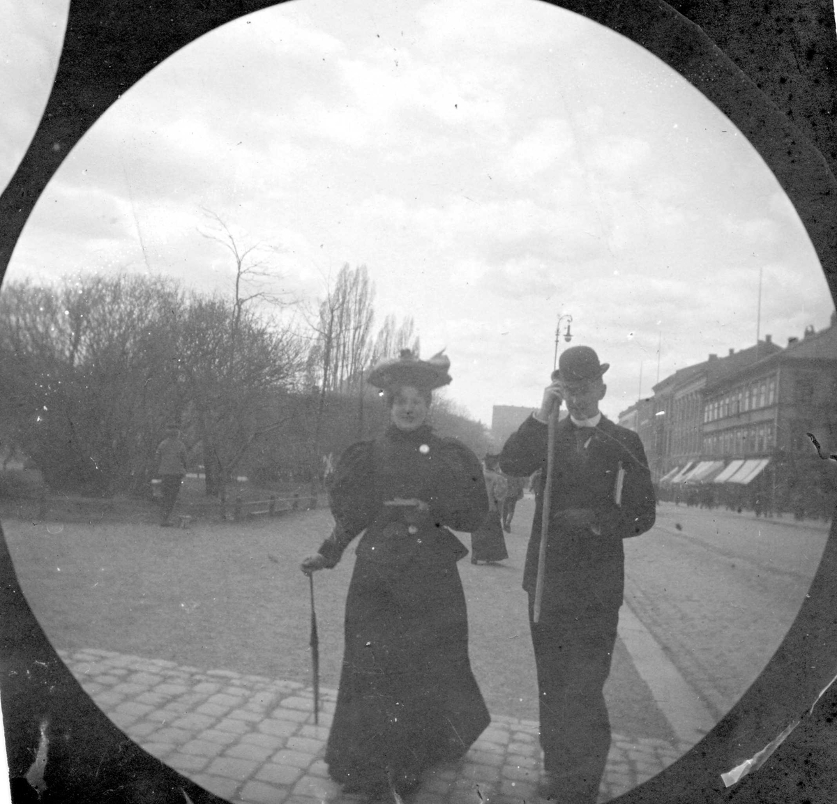Fredrik Carl Mülertz Størmer, Chrristoffer Larsen, Skien, og en kvinne spaserer langs Karl Johans gate, Oslo.