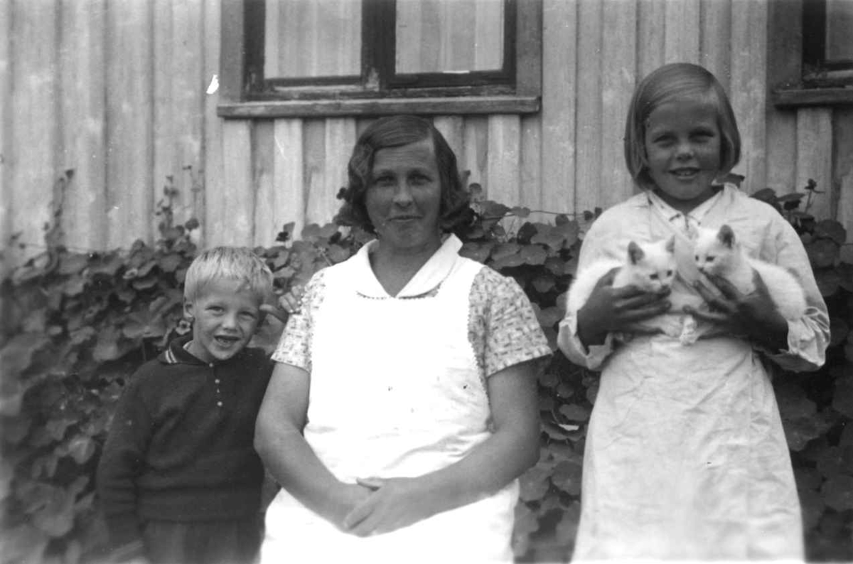 Anna Grostøl, Fru Olav Ramse med to barn, Jenta holder i to kattunger. Tovdal 1936.