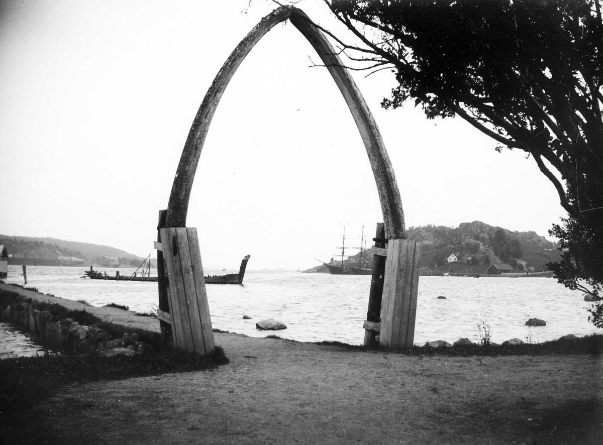Juliane Fredrikke Langberg, Portal, muligens av hvalbein, for enden av brygge. Muligens i Hurum. Skip på (Oslo?)fjorden i bakgrunnen. Fra malerinne Juliane Fredrikke Langbergs (1856-1930) samling, tatt ca.1895-1910 med motivkrets slekt og venner samt steder tilknyttet samvær med disse.