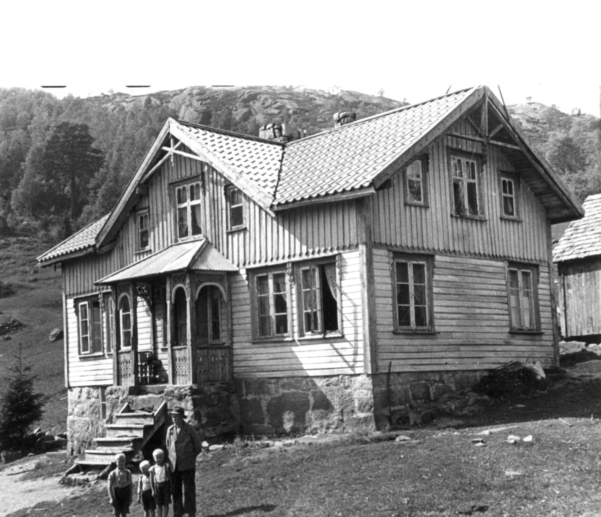 Anna Grostøl, En mann og tre barn foran gannehuset til Eftestøl. Fjotland, Kvinesdal 1941.