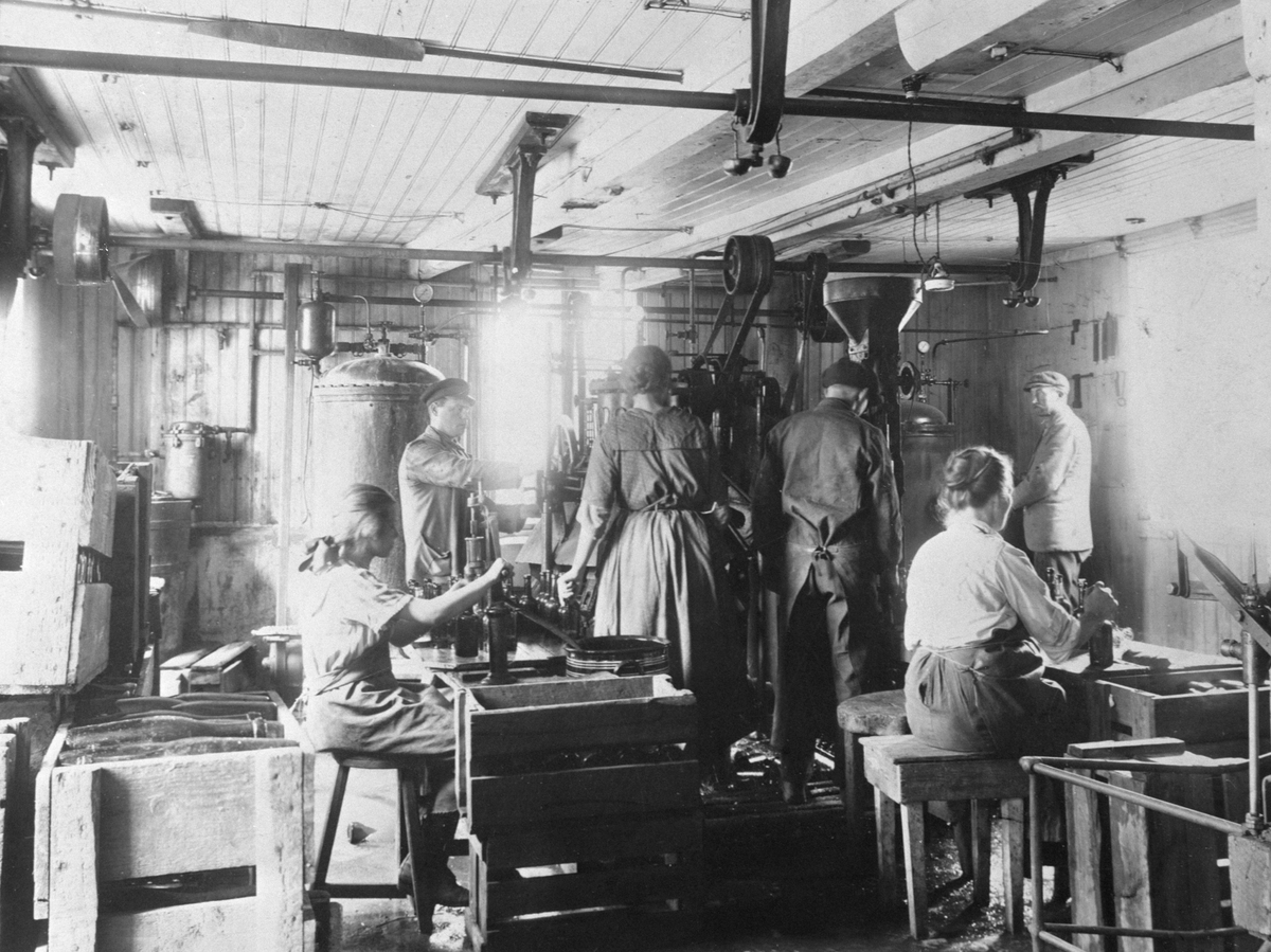 Anno Domkirkeodden, Bergsund-bryggeriet. Mineralfabrikken Fram, Stangevegen, Blystadgården. Fram brusfabrikk. Interiør. Foran f.v. Borghild Olsen, Olga Olsen. Bak f.v. arbeidsformann Kristian Lauritzen, Johanne Andersen, brustapper Olaf Olsen, vognmann Ole Olsen..