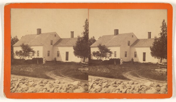 Unknown, [View of house with two women in the yard, white stone fence in foreground]
