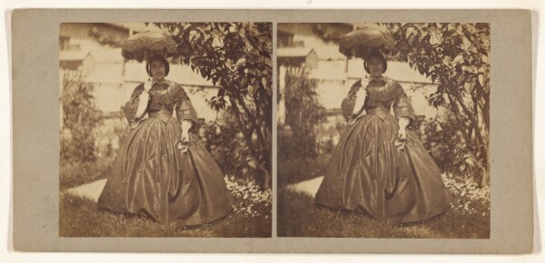 Unknown, [Woman standing in a garden, holding a parasol]
