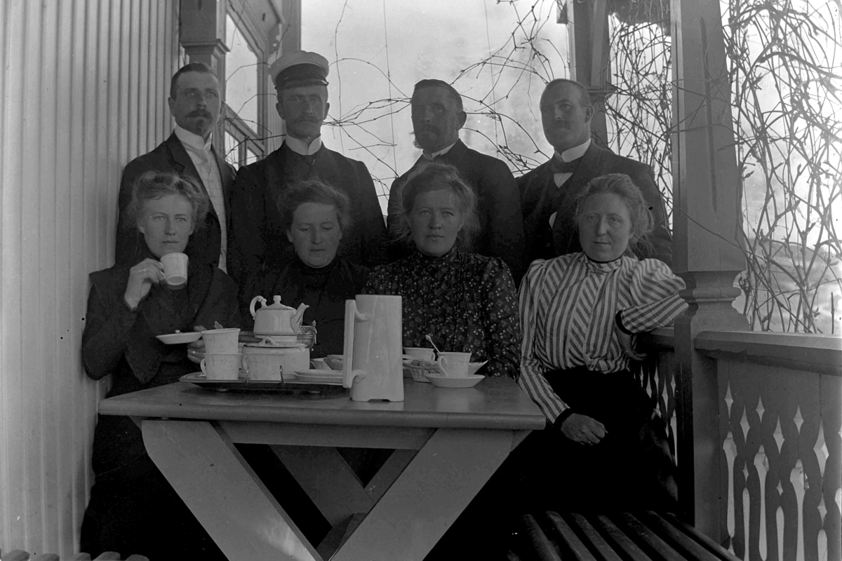 Ole Hansen Løken, Gruppe 8, veranda, kaffe, kaffeselskap, kaffeservice. Bildet er fra verandaen på Haugen (Veldre, Ringsaker) og viser fire søsken med respektive ektefeller. I bakre rekke, fra venstre: Halvor Skappel, Ole Hersoug, Ole Løken (fotografen) og Barthold Ring. I fremste rekke: Lally Skappel (f. Ring), Tul…