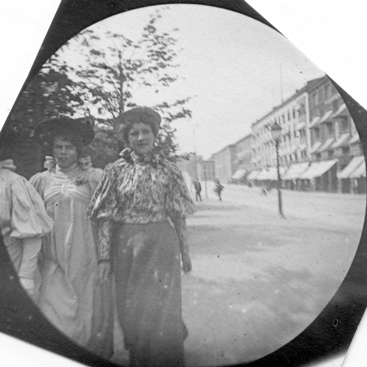 Fredrik Carl Mülertz Størmer, Tre kvinner med ant. frk. Engelschjøn i midten, spaserer langs Karl Johans gate, Oslo. Universitetet skimtes.