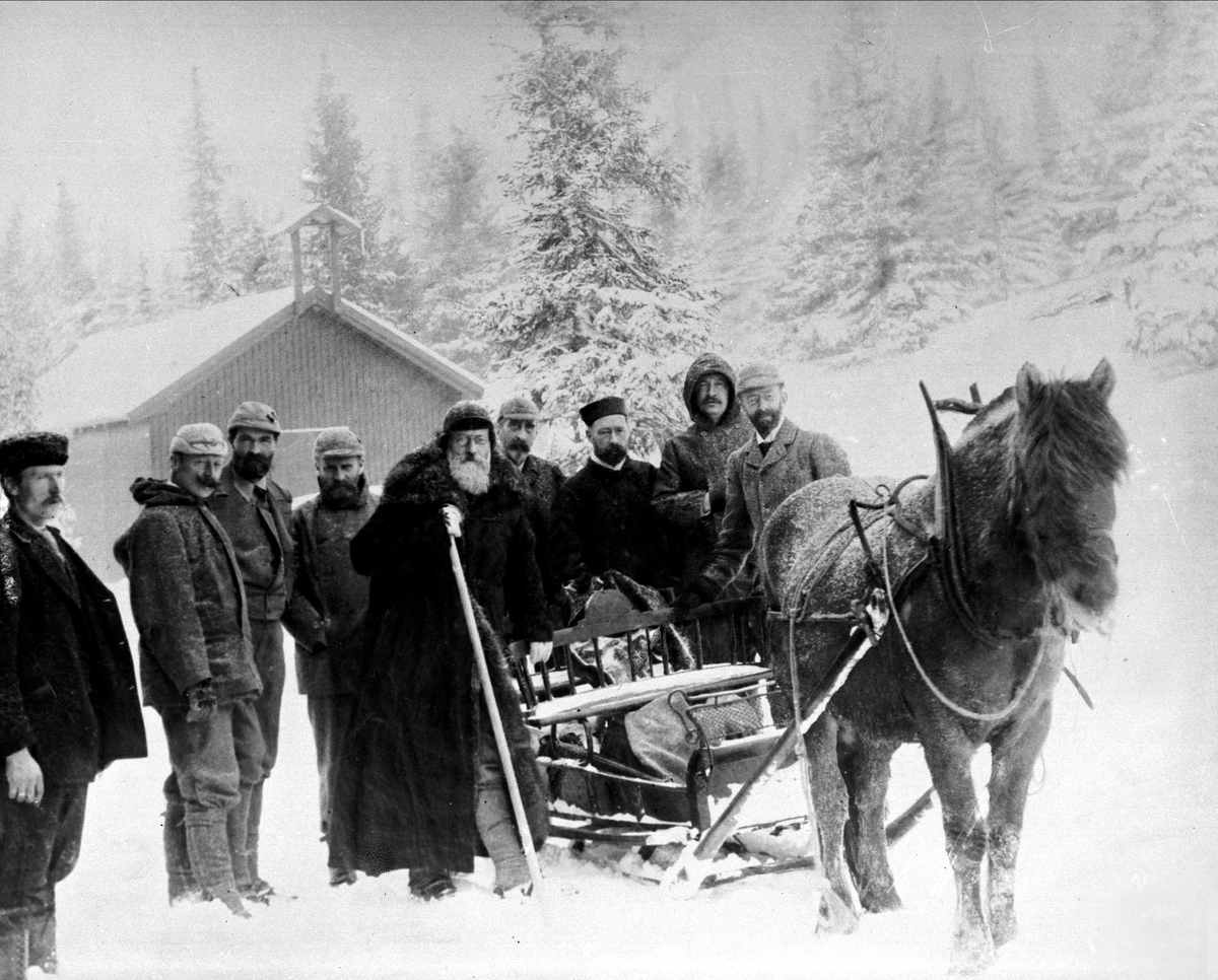 Gustav Borgen, Avfotografering. Gruppe, ni menn ute i snøen bak en hest med slede.