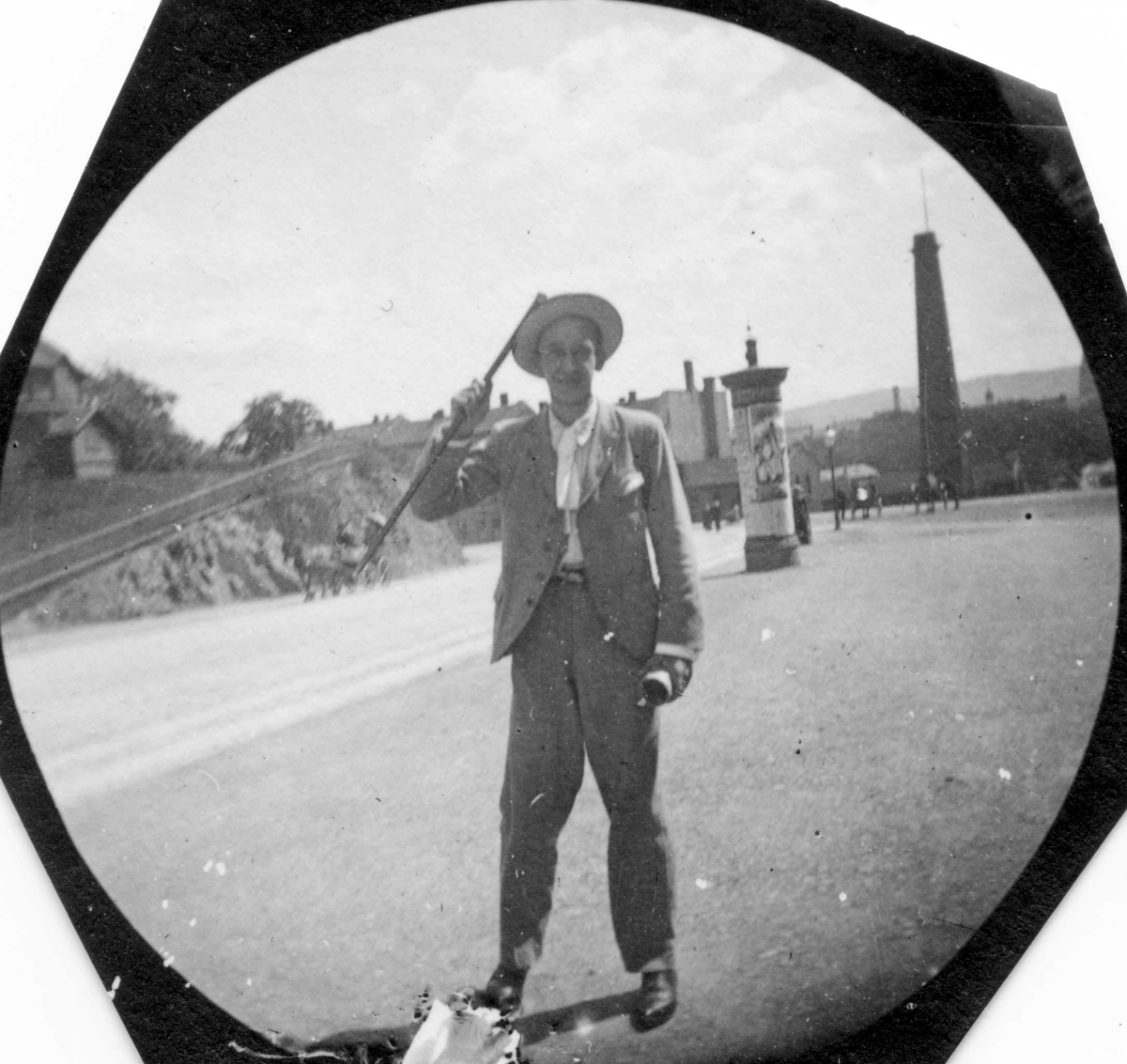 Fredrik Carl Mülertz Størmer, Niels Schiott (?) står på gressplen ved siden av vei. Hestevogn i veien og bybebyggelse, ant. Oslo. Reklamesøyle i bakgrunnen.