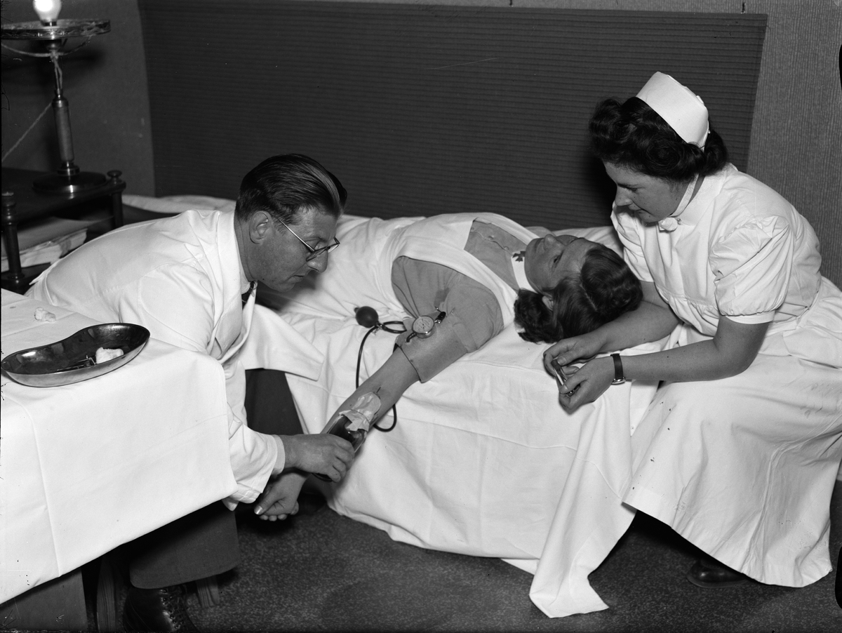 Paul Sandberg, "Personalen på Ulleråker lämnar blod till armén" - läkaren Evert Ljungberg och sjuksköterskan Karin Bengtsson under en blodtappning, Ulleråkers sjukhus, Uppsala oktober 1941