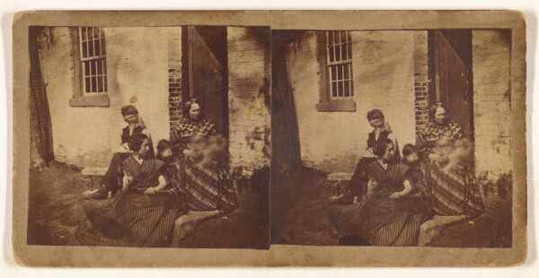 Unknown, [Family posed at entrance to house]