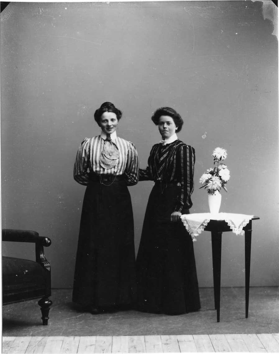 Calla Helena Sundbeck, Group image with two young women in striped blouse and long dark dress. The woman on the right is Jenny Johansson from Örserum.