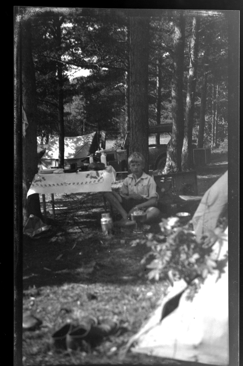 Rolf Sr. Sundt, Rolf Sundt Jr. ved campingbord på teltplass ved Fevik. Fotografert juli 1932.